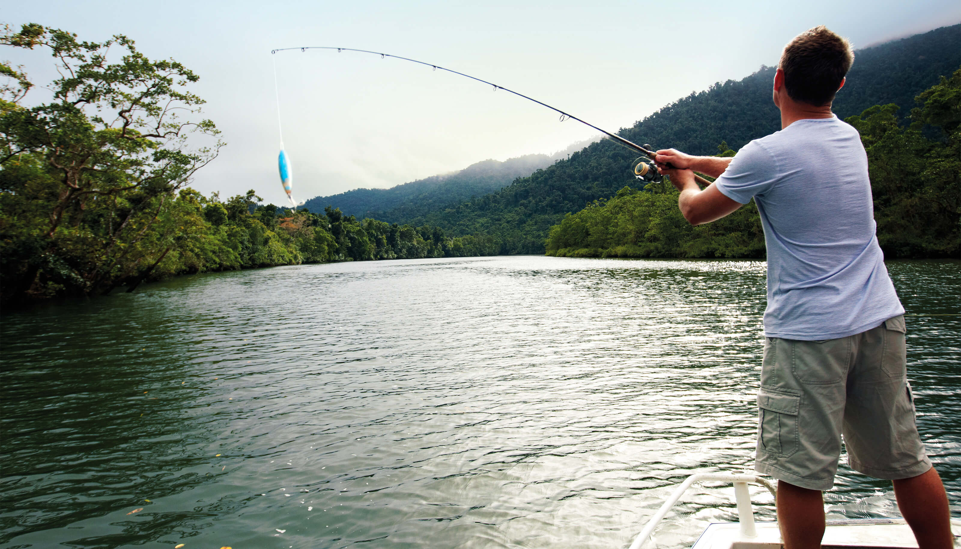 man fishing from boat in river