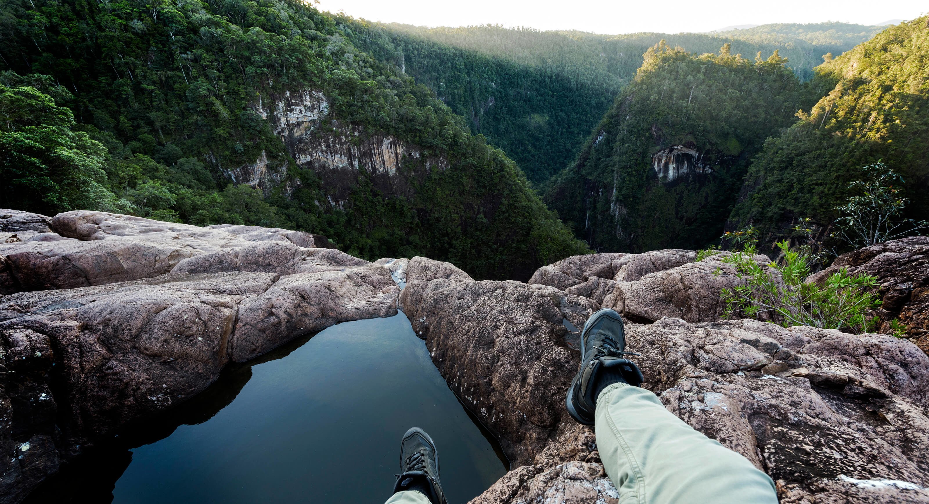 hiker sitting on edge of cliff