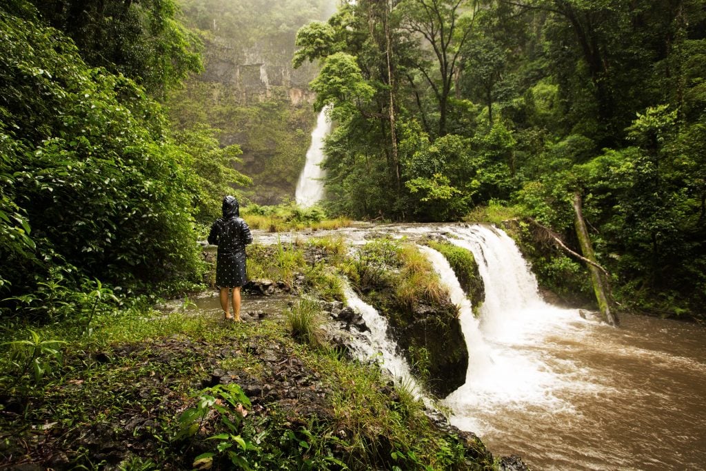 girls standing in rain at nandroya falls atherton