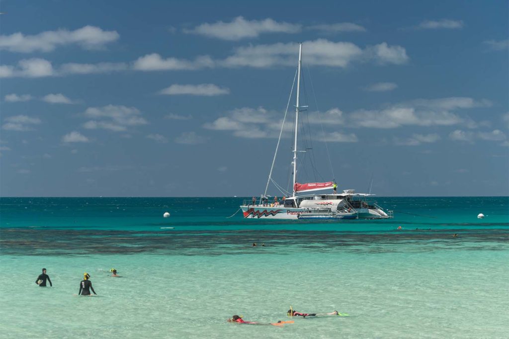 Snorkellers swimming the reefs of the Great Barrier Reef with Passions of Paradise reef boat in background