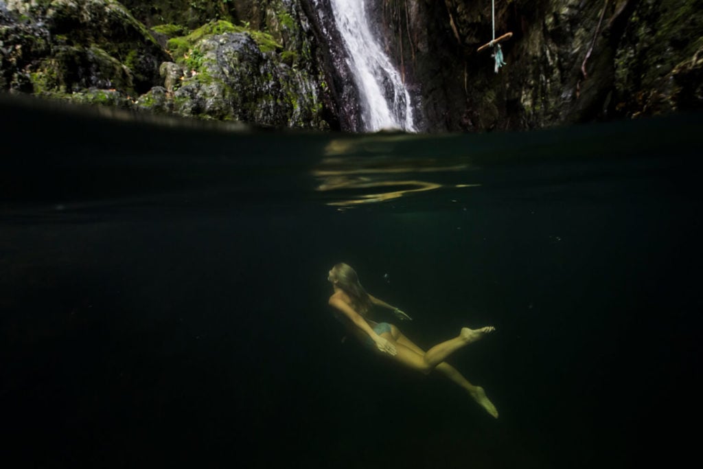 Young woman swimming at Fairy Falls