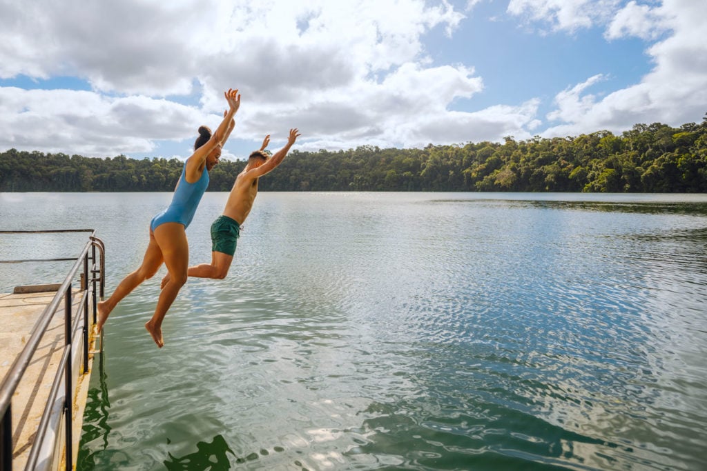 couple jumping into lake eacham