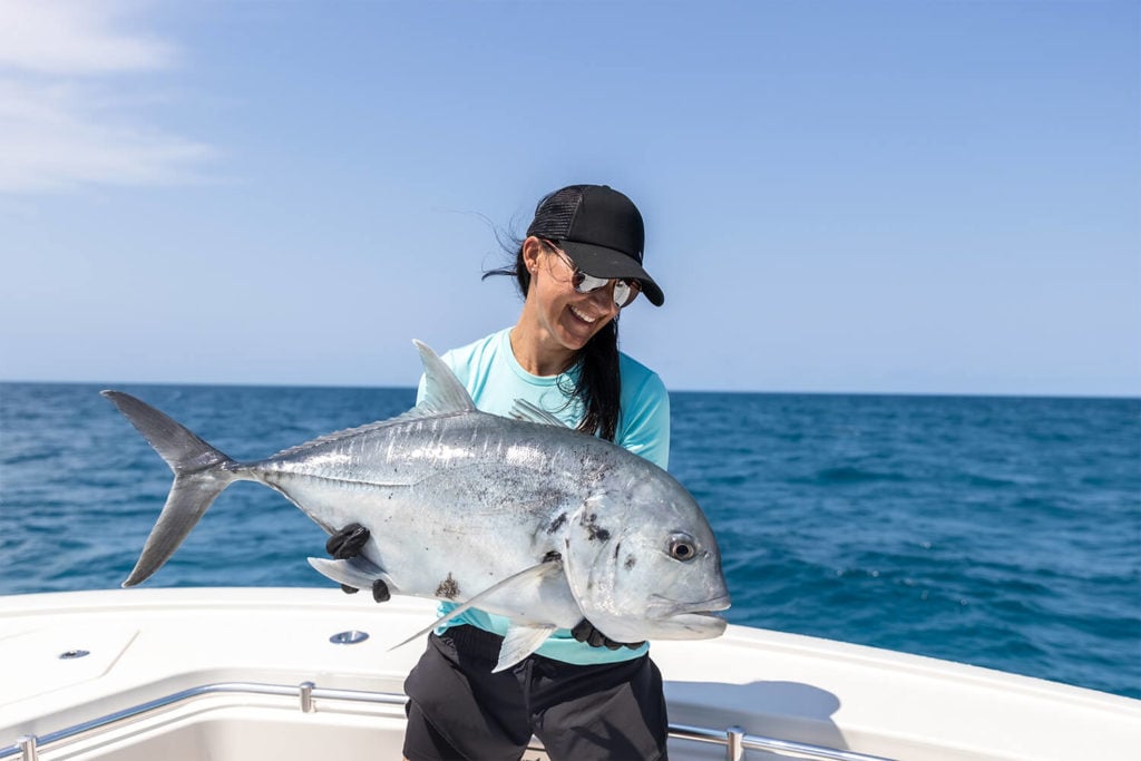 Woman with Giant Trevally caught on East Coast Angling fishing charter