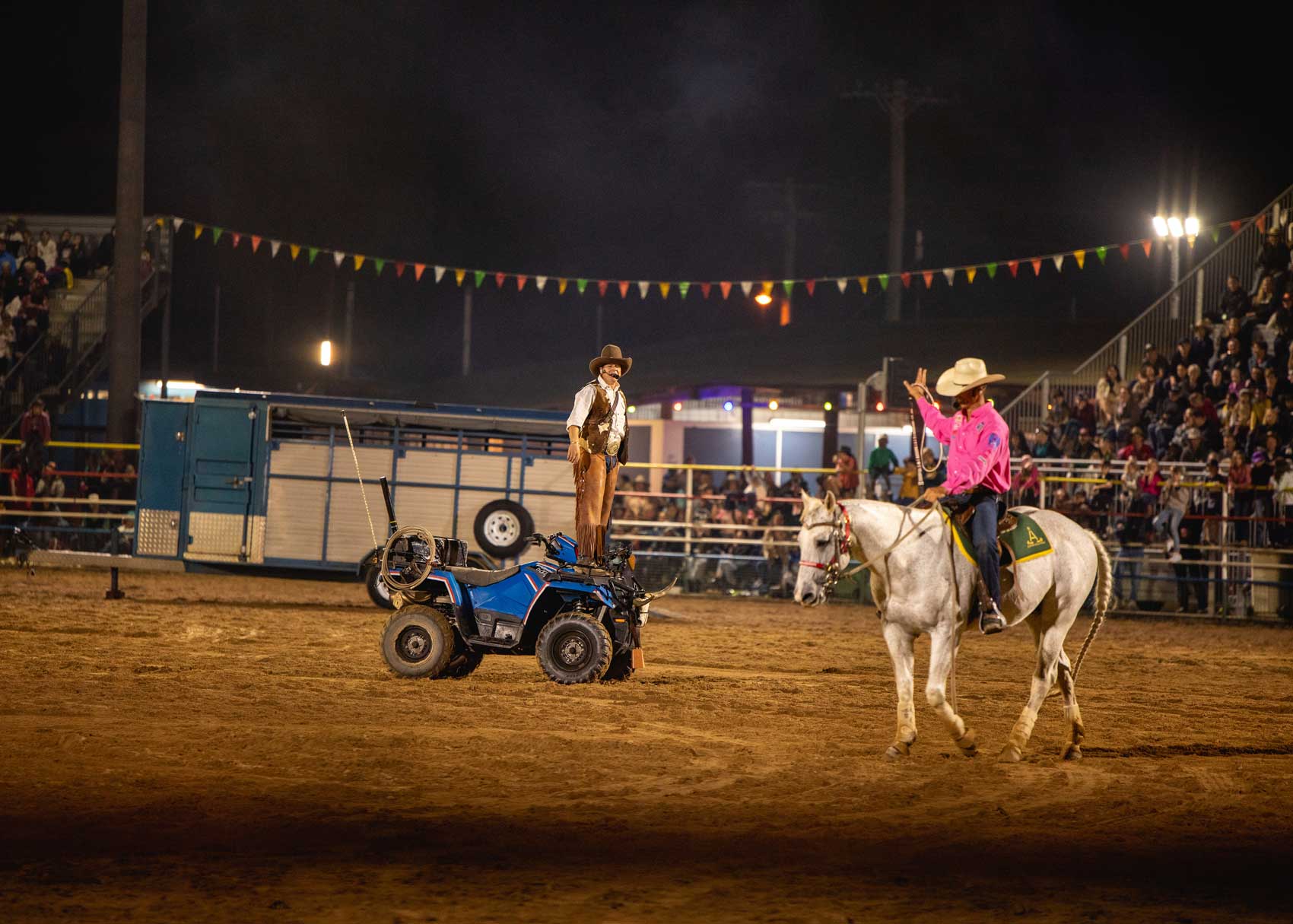 man riding horse and man with tractor at the mareeba rodeo