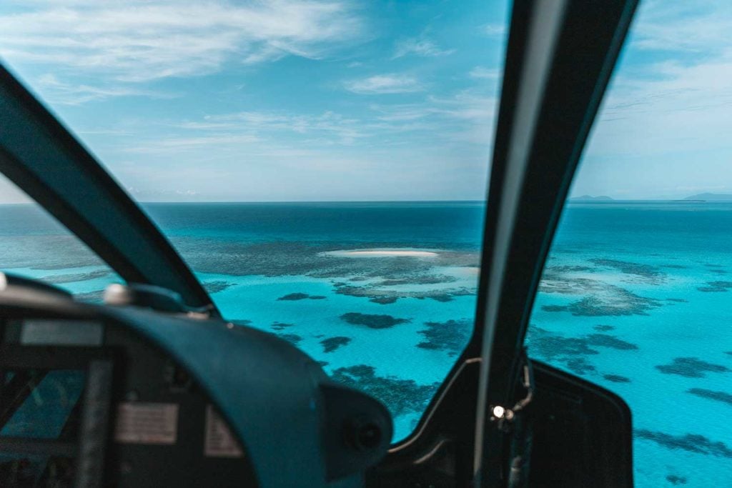 Great Barrier Reef and Vlasoff Cay framed by helicopter interior on scenic flight
