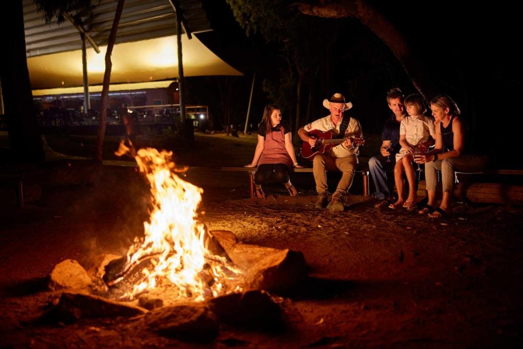 Family and Savannah guide around nightly camp fire at Undara Experience